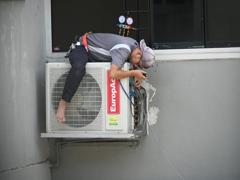 HVAC technician working on air conditioning unit